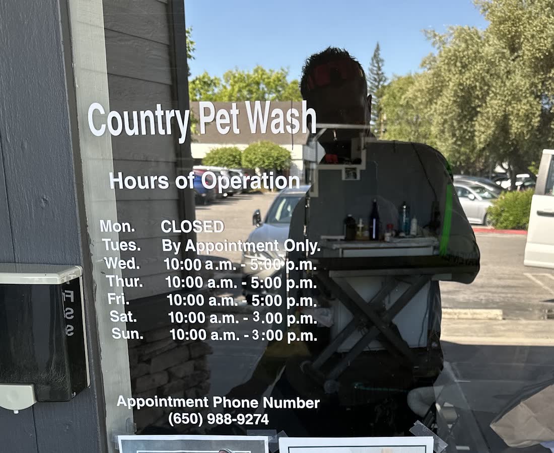 The Country Pet Wash glass front door with the business name and posted hours of operation
