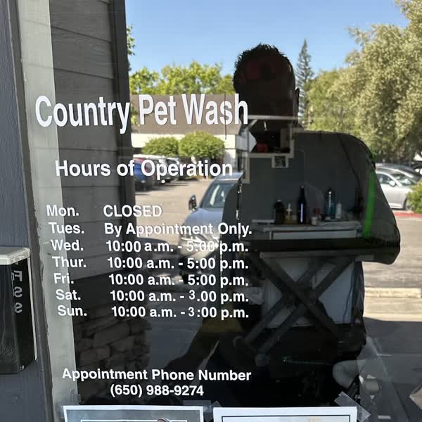 The Country Pet Wash front door with the business name and posted hours